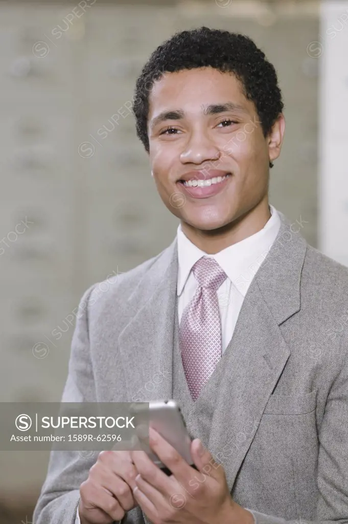 Mixed race businessman holding cell phone