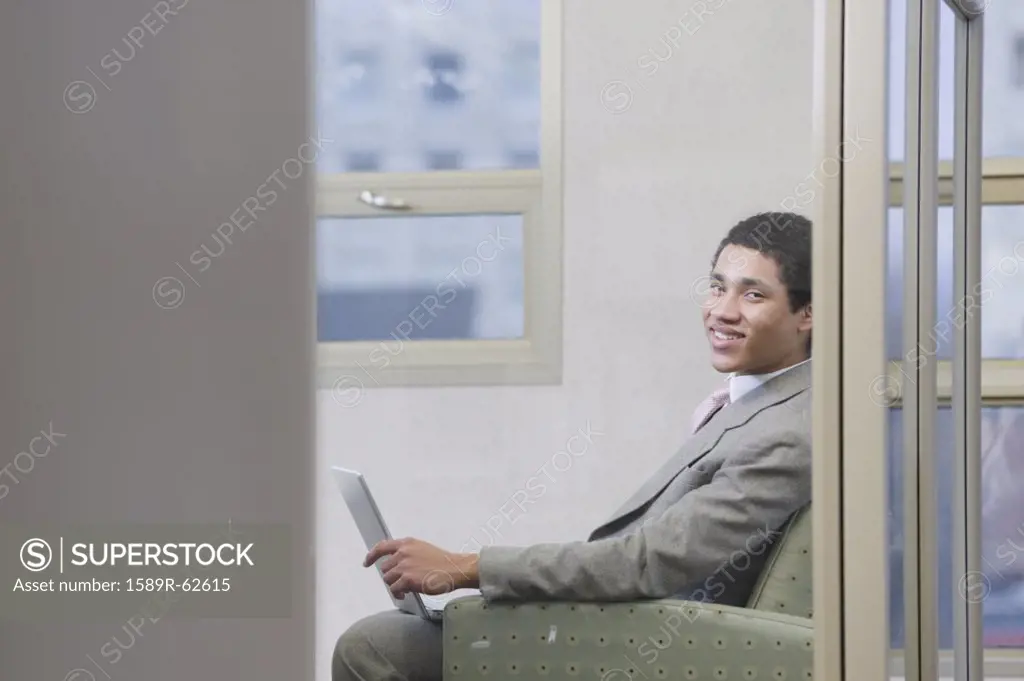 Mixed race businessman working on laptop in office