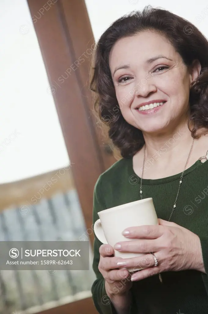 Mixed race woman holding coffee mug