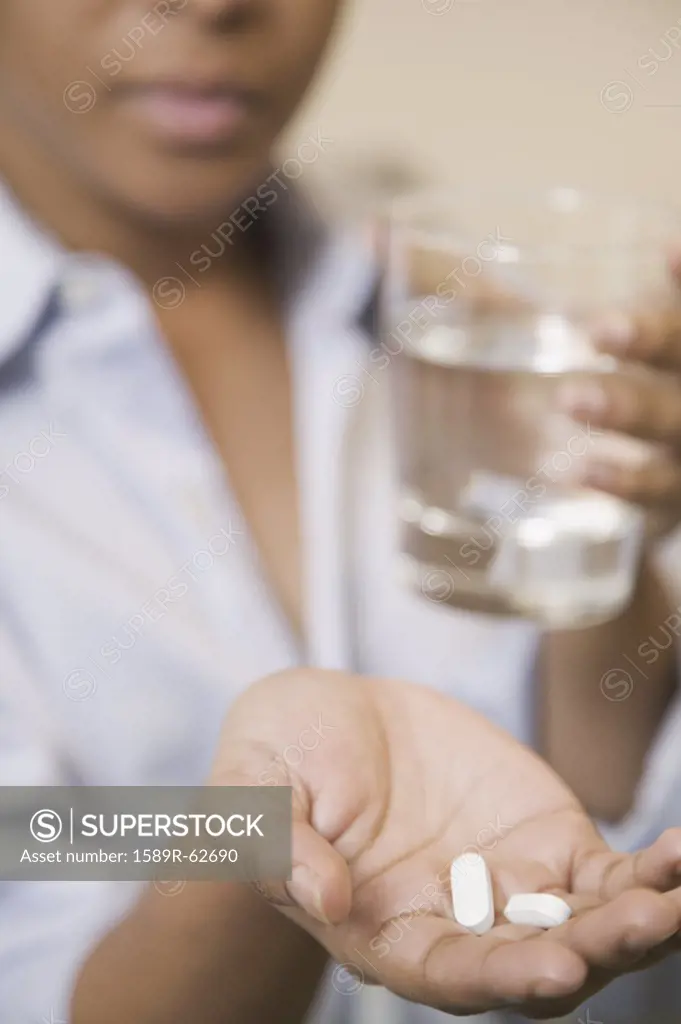 Close up of African woman holding pills