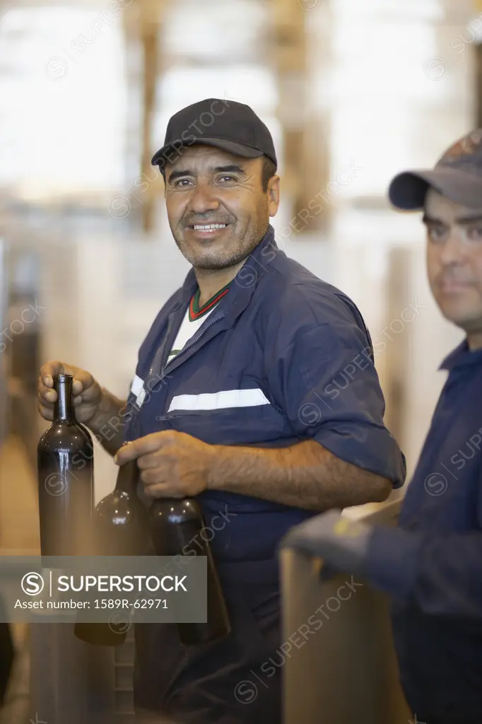 Hispanic men working in bottling factory