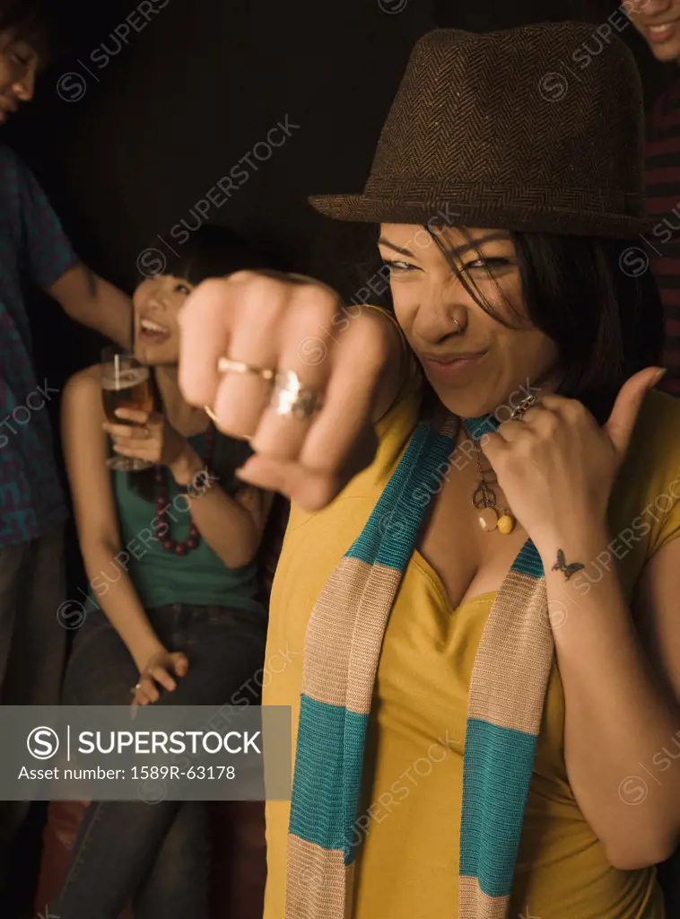 Mixed race woman punching air in nightclub