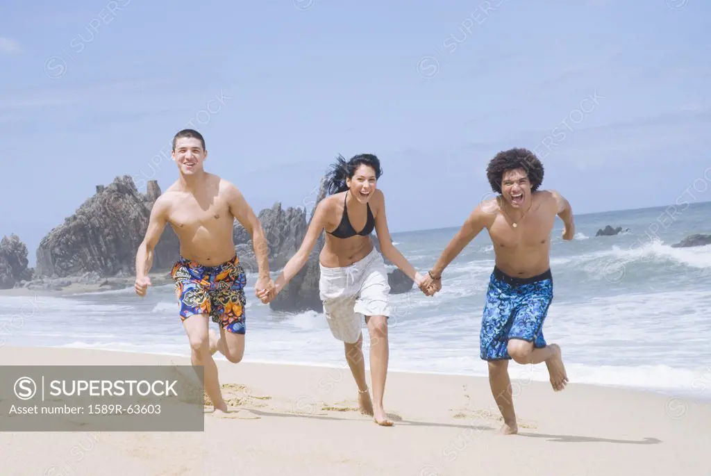 Multi-ethnic friends running on beach