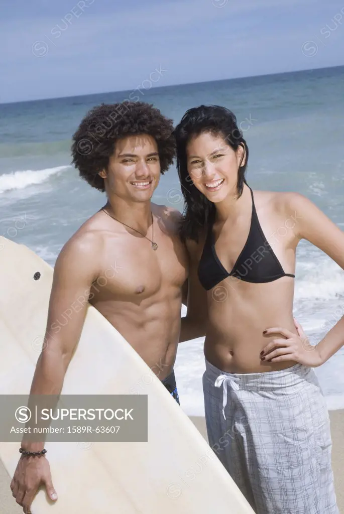 Couple with surfboard at beach