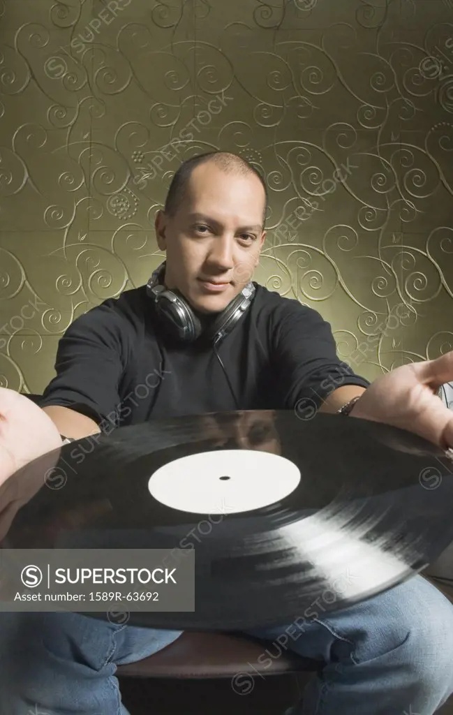 Hispanic man holding vinyl record