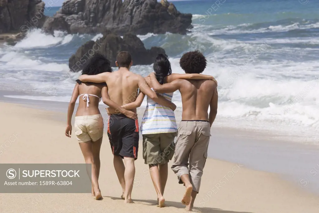Multi-ethnic friends walking on beach