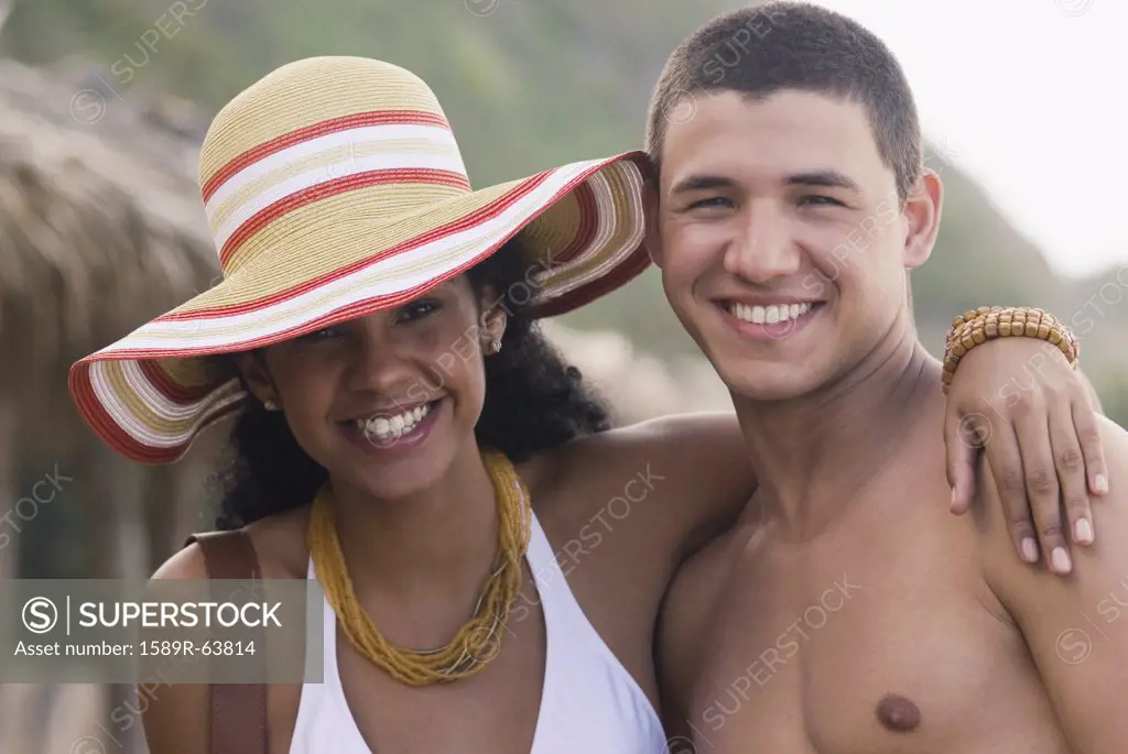 African woman hugging boyfriend at beach