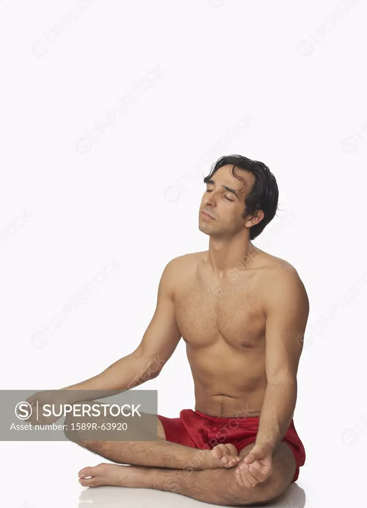 Bare chested Middle Eastern man meditating