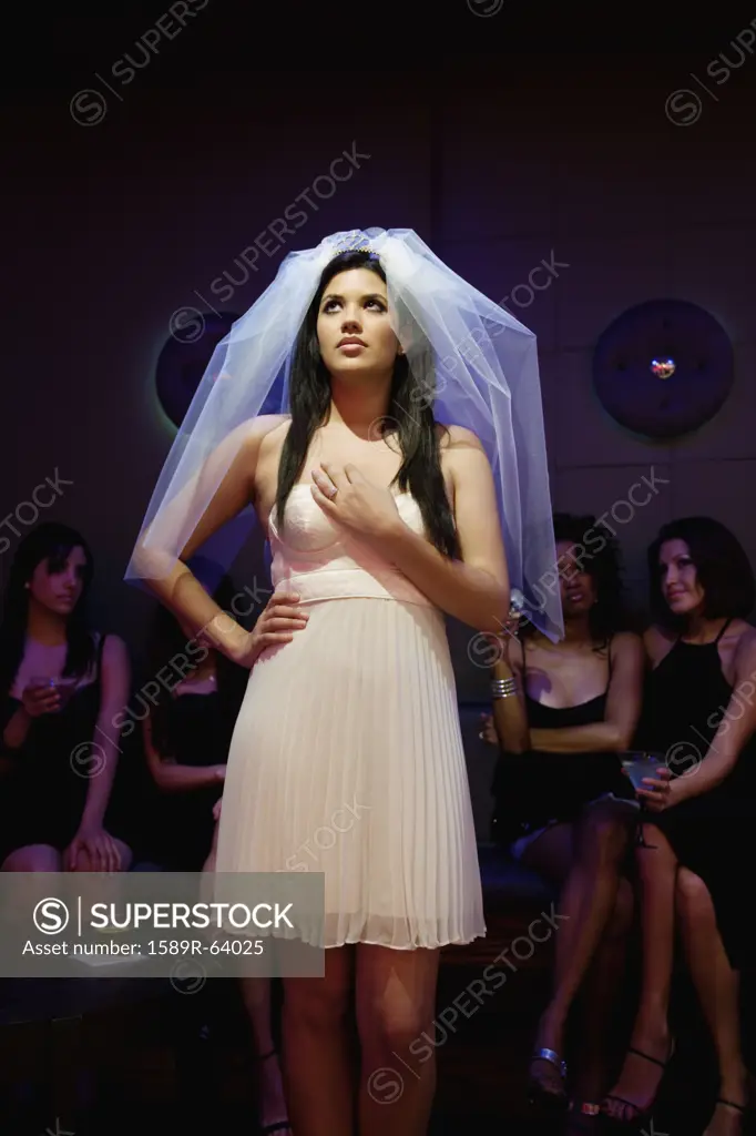 Bride wearing veil standing in nightclub