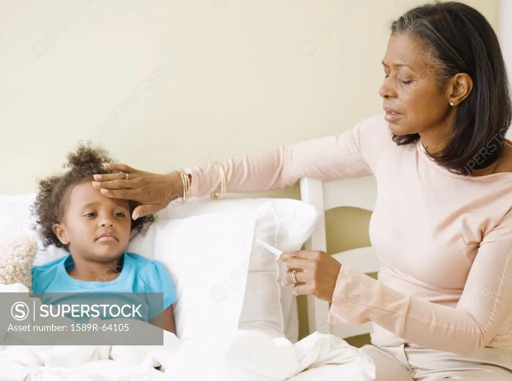 African grandmother checking granddaughters temperature