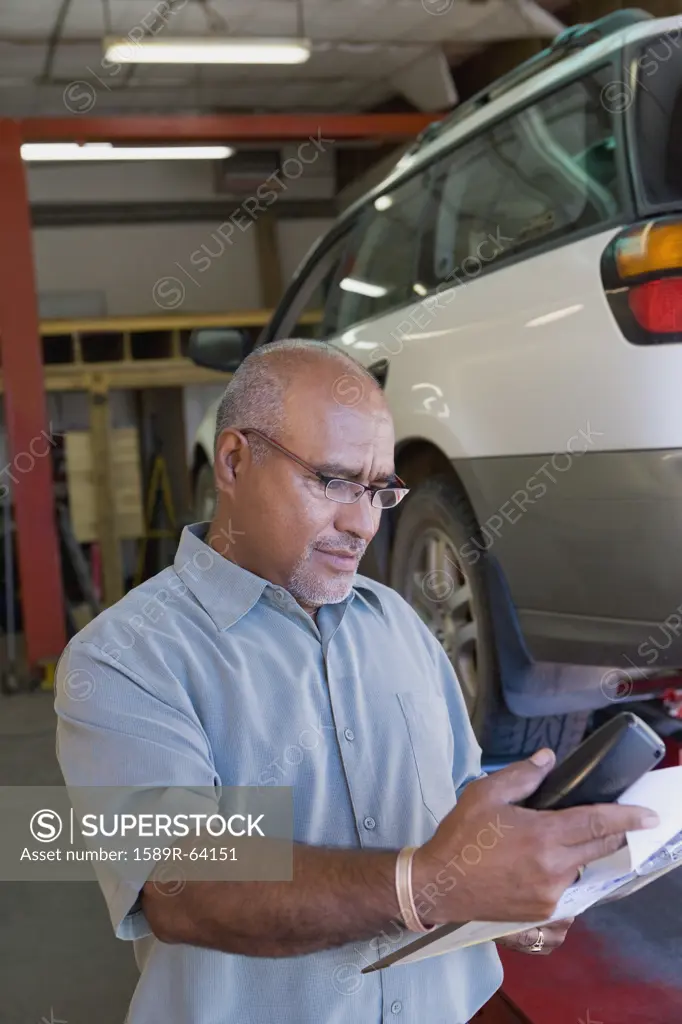 Hispanic mechanic working in auto repair shop