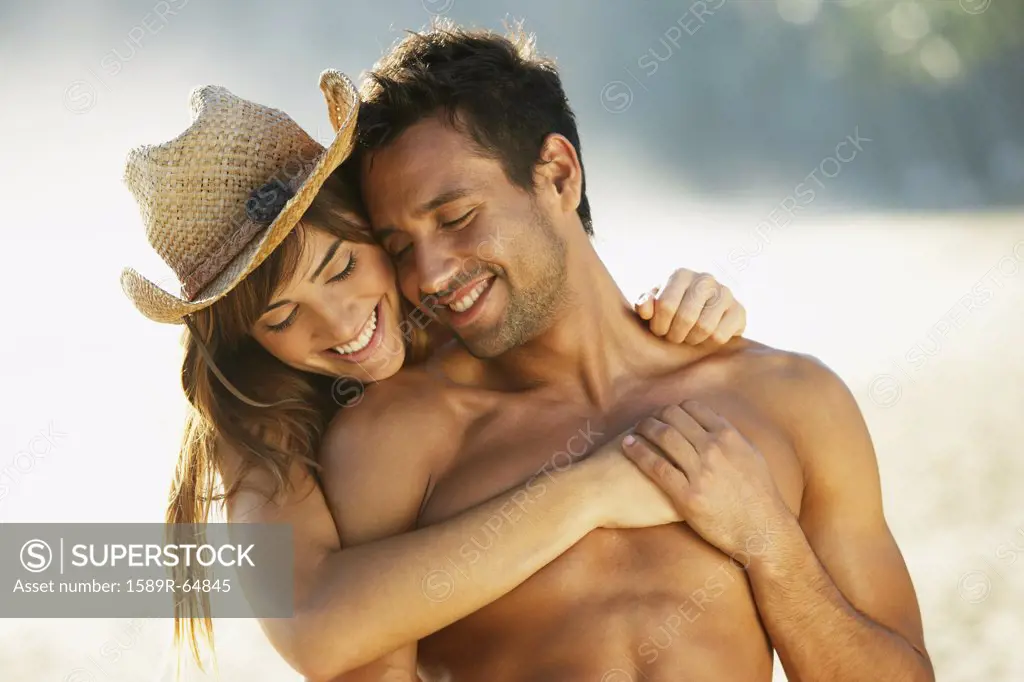 Smiling couple hugging at beach