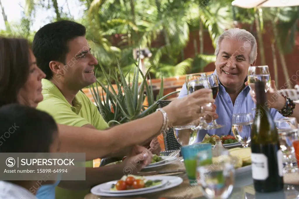 Family enjoying healthy lunch and drinking red wine