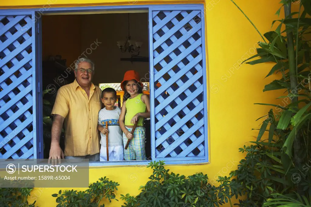 Grandfather looking out window with grandchildren