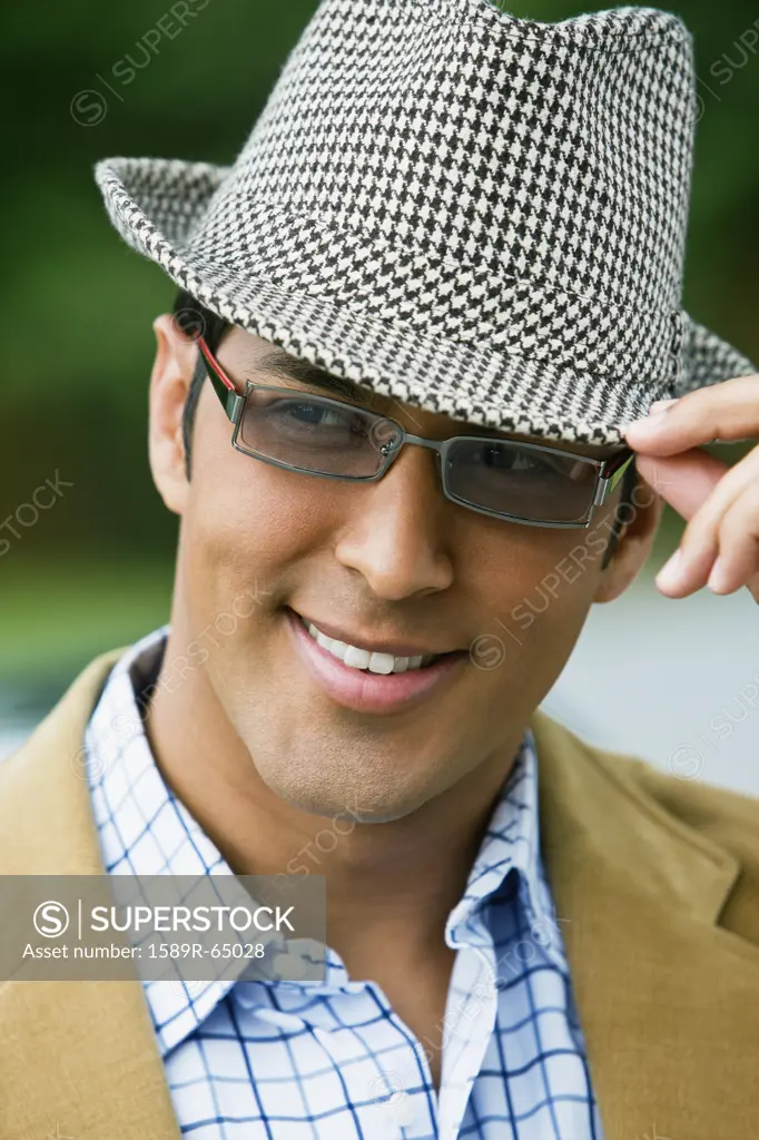 Hispanic man adjusting hat