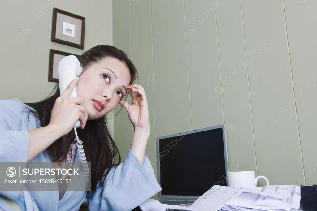 Stressed woman talking on telephone