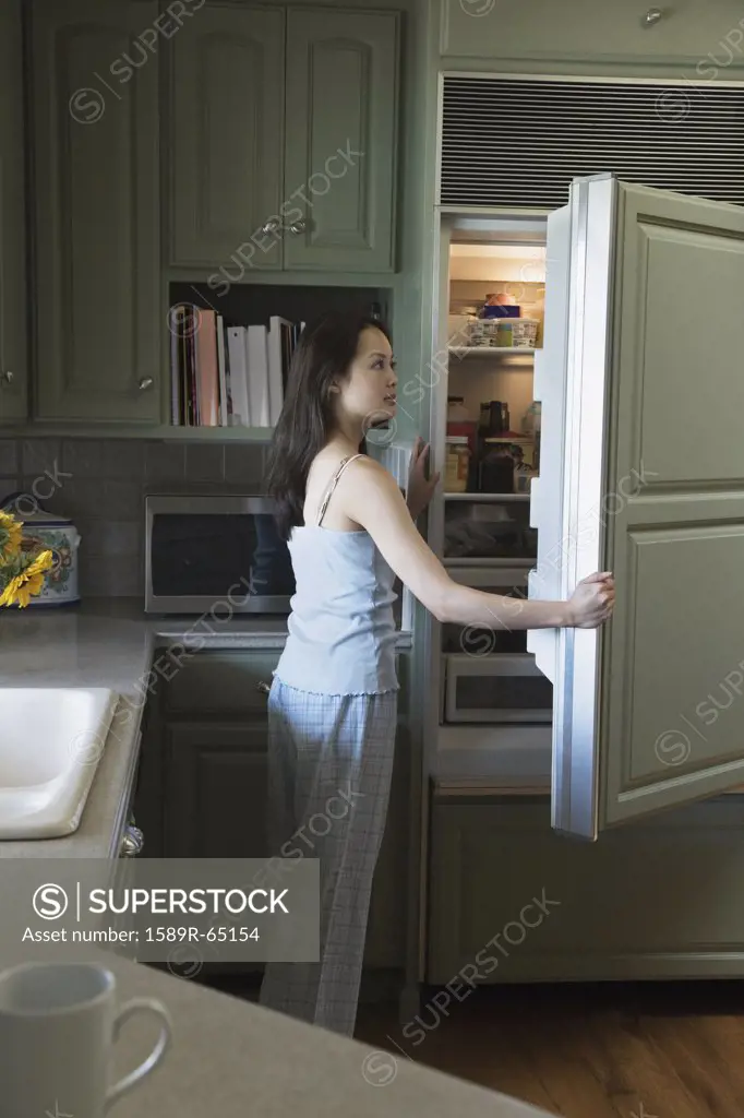 Woman opening refrigerator door