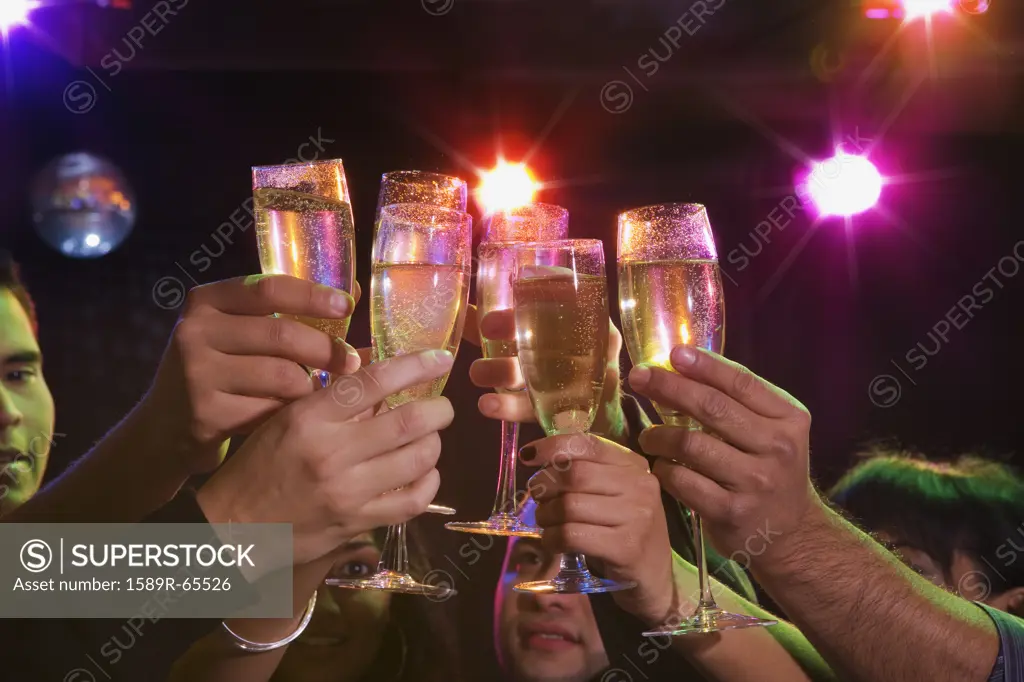 Hispanic friends drinking champagne in nightclub