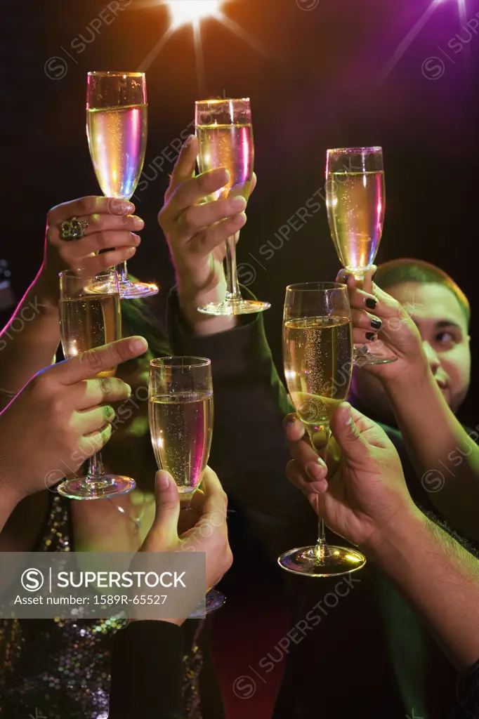 Hispanic friends drinking champagne in nightclub