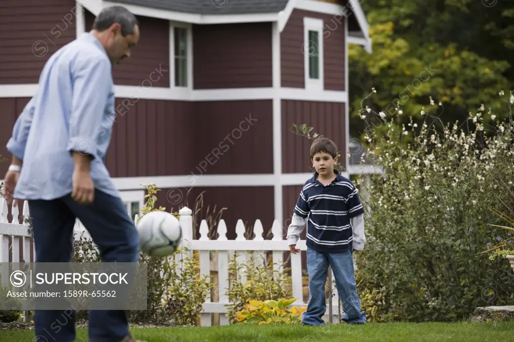 Father and son playing soccer