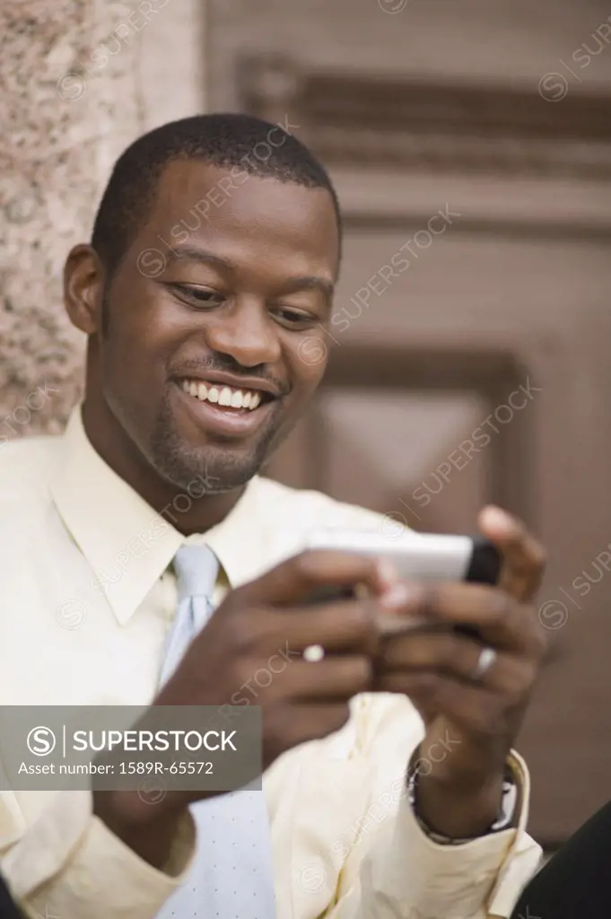 African businessman sending text message