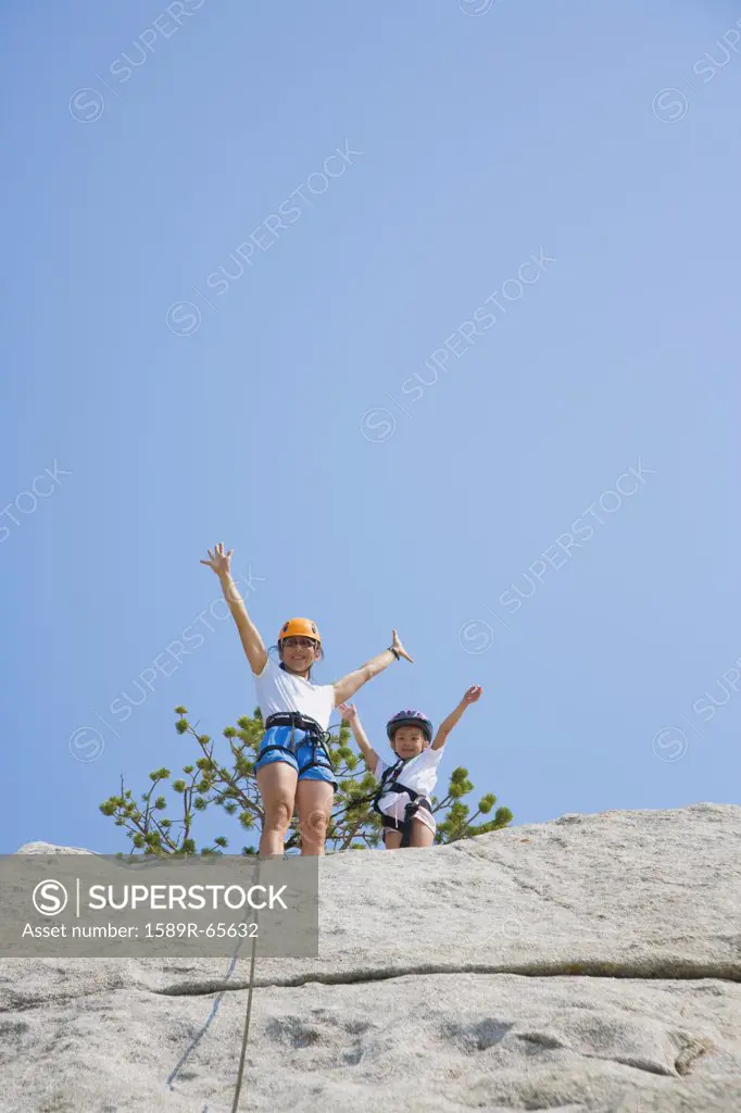 Asian mother and daughter rock climbing