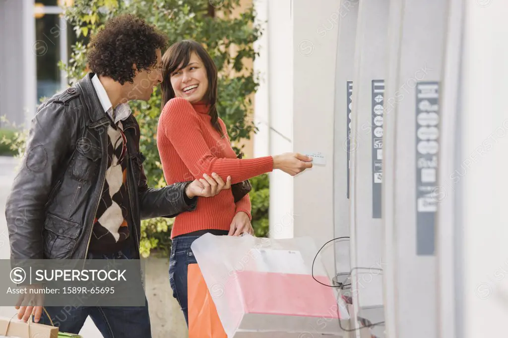 Couple with shopping bags at ATM