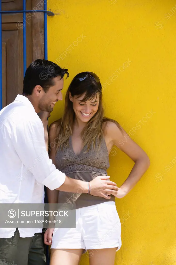 Couple standing together near wall