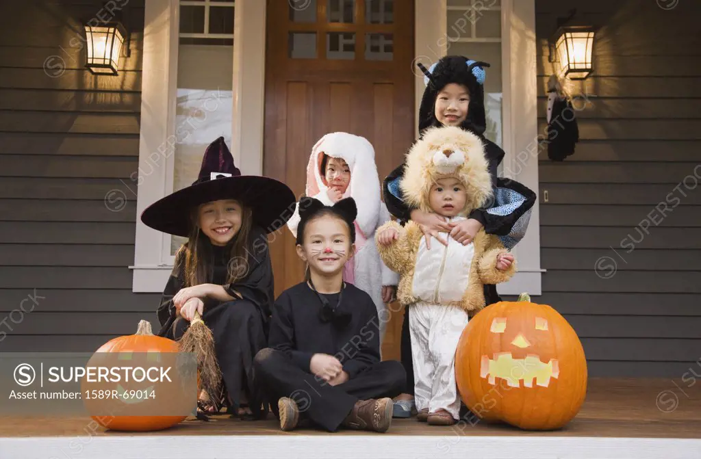 Children in Halloween costumes with pumpkins