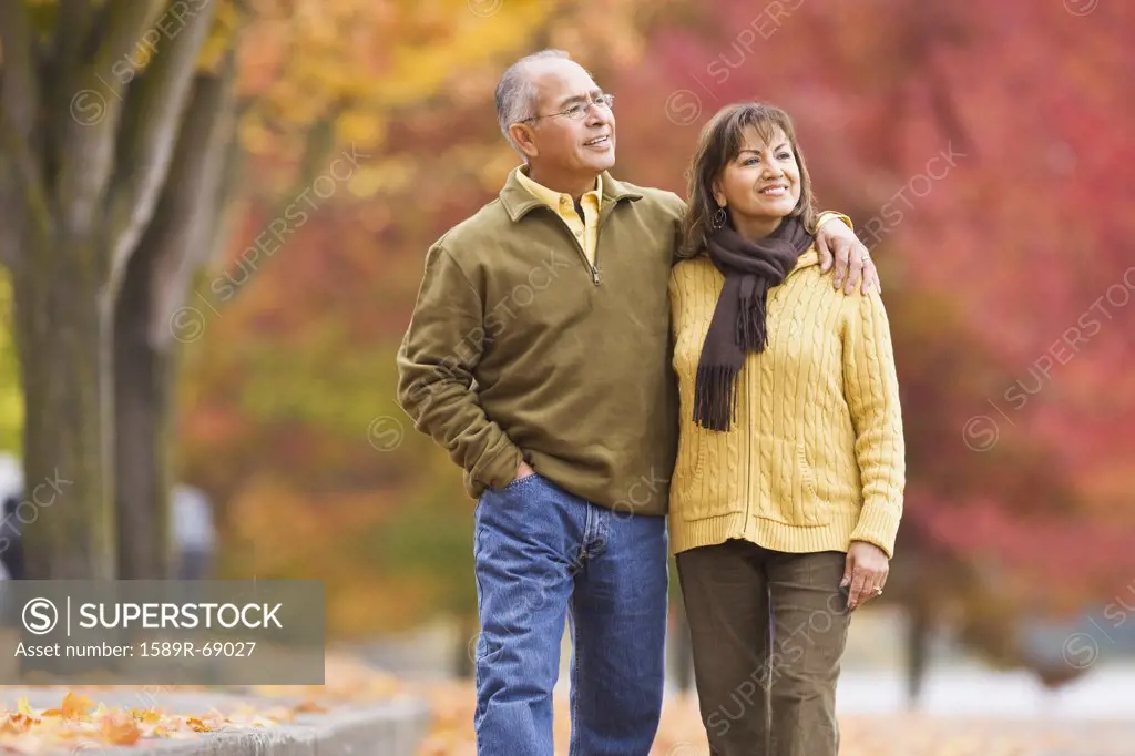 Hispanic couple walking outdoors in autumn