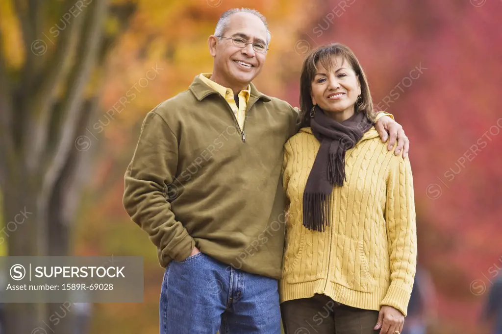Hispanic couple standing outdoors in autumn