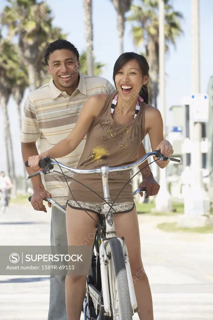 Young couple standing with tandem bicycle