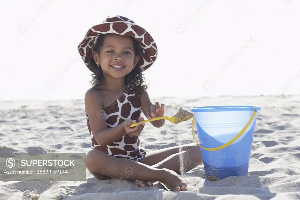 Young mixed race girl playing at beach