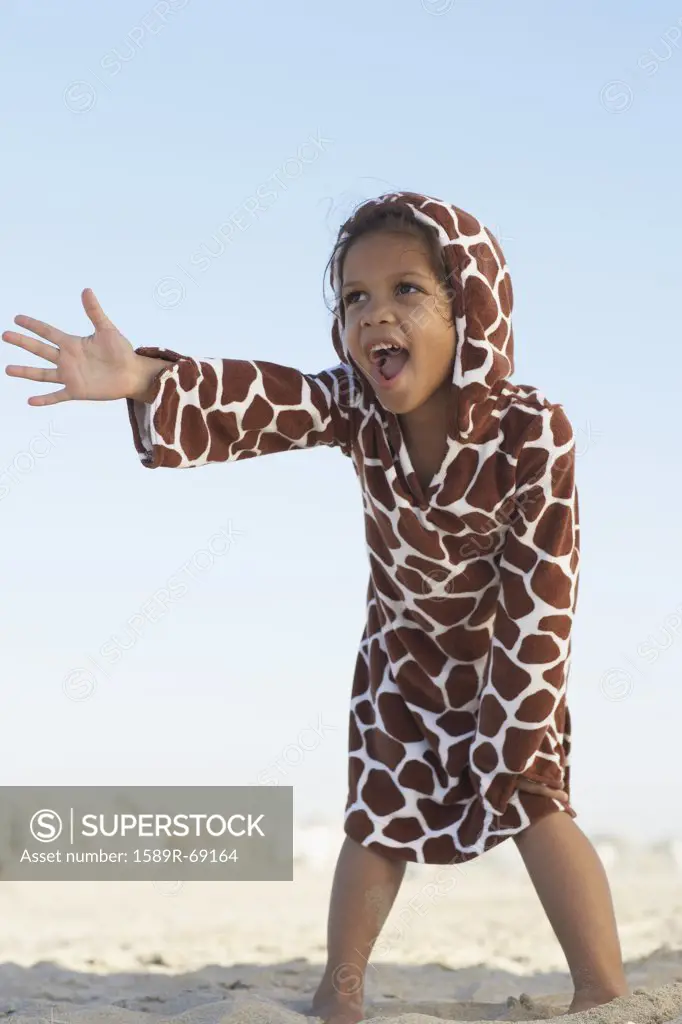 Young mixed race girl gesturing on beach wearing hoody