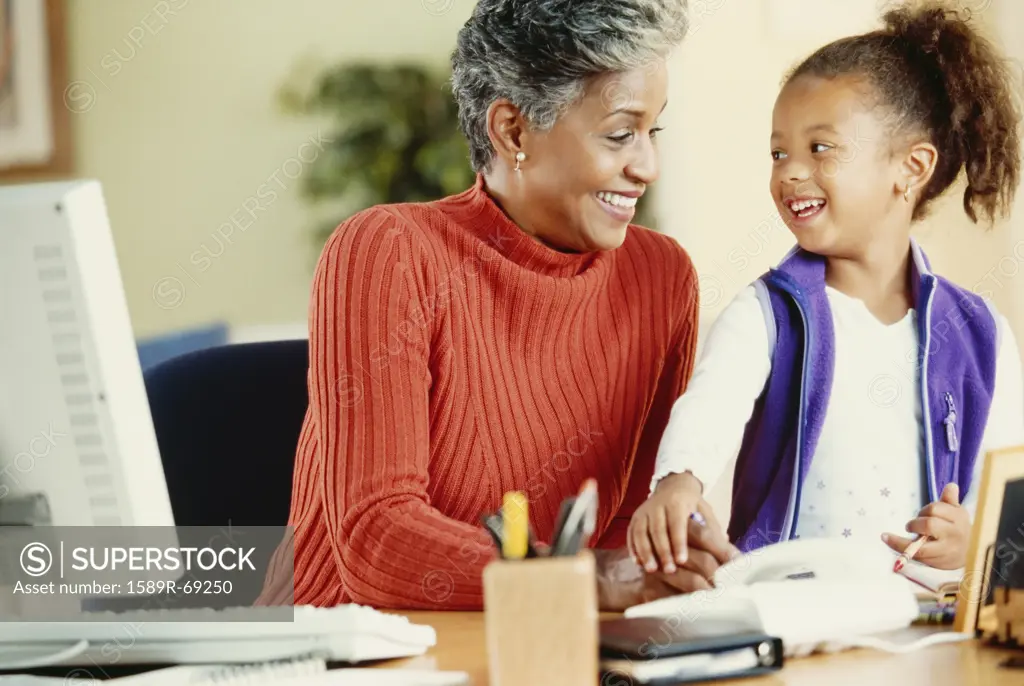African grandmother and granddaughter in home office