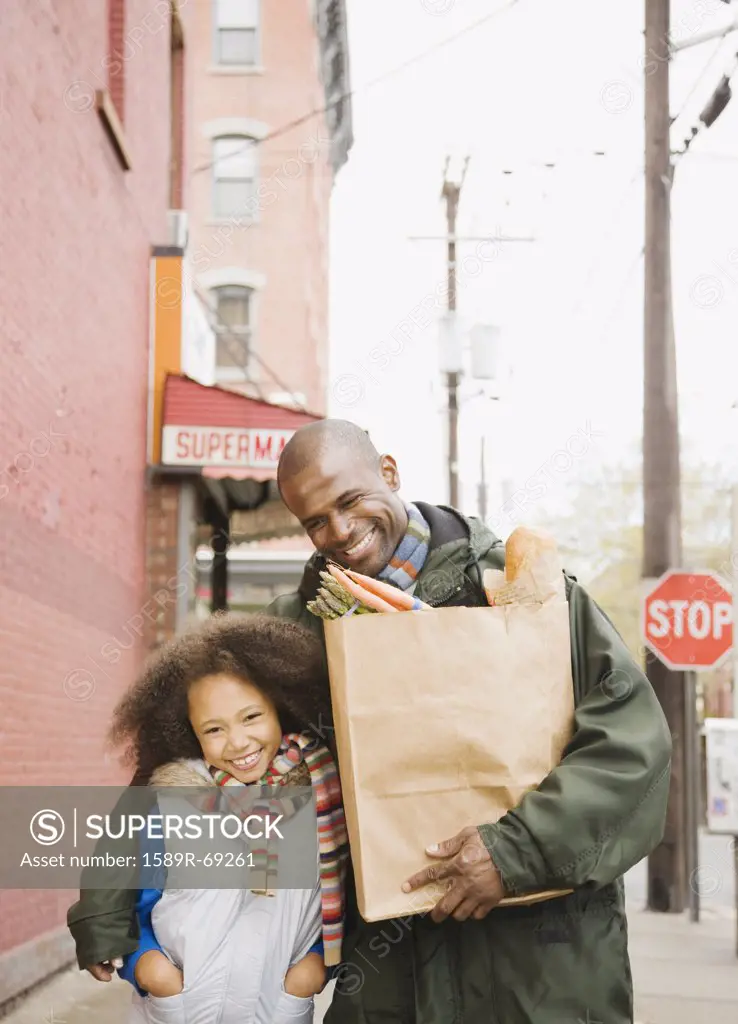 African father and daughter with groceries