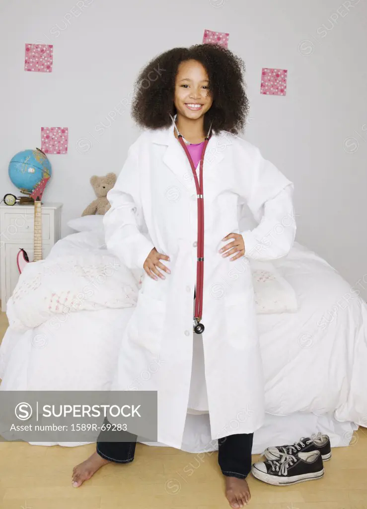 African girl dressed as doctor in bedroom