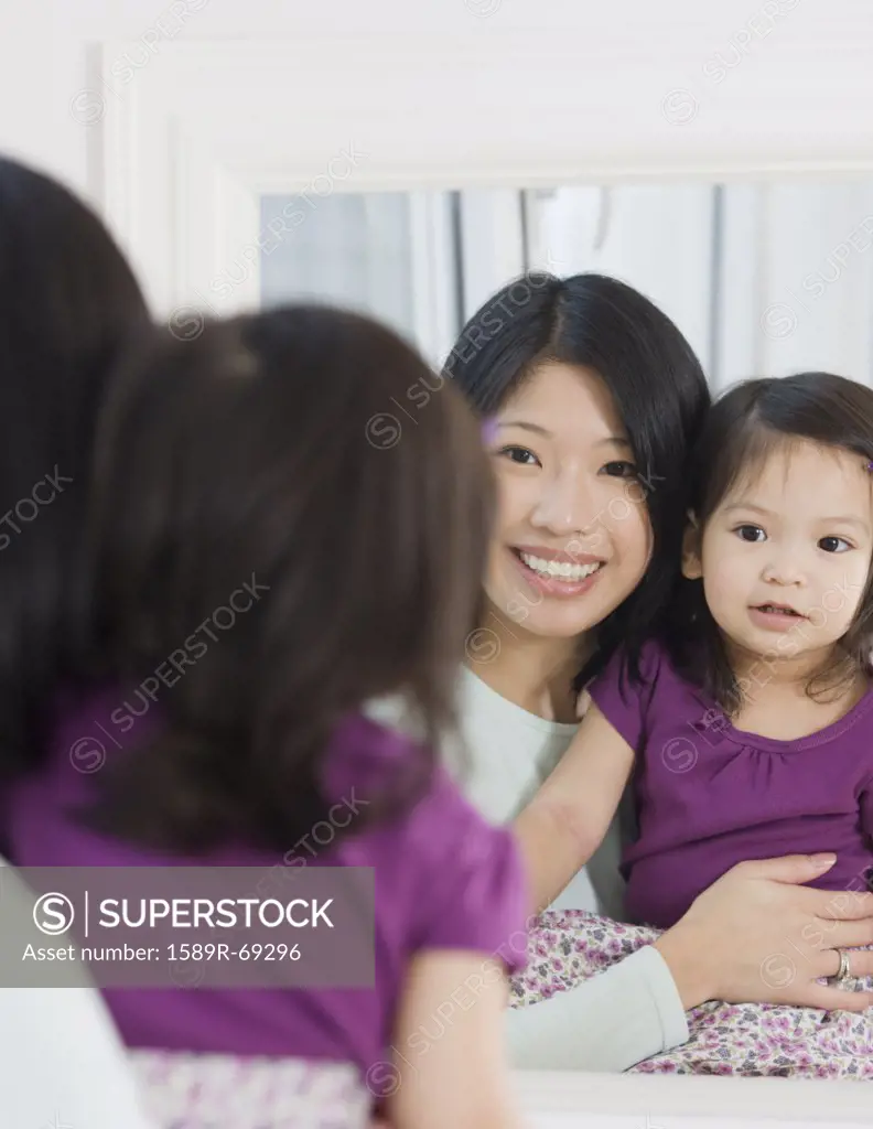 Mother and daughter looking in mirror
