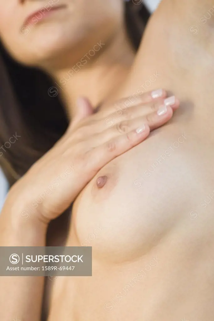 Close up of Hispanic woman doing breast self-exam
