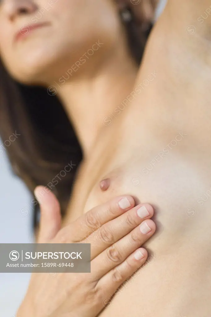 Close up of Hispanic woman doing breast self-exam