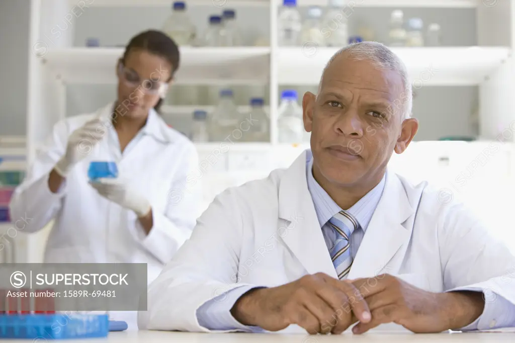 African scientist in laboratory with co-worker in background