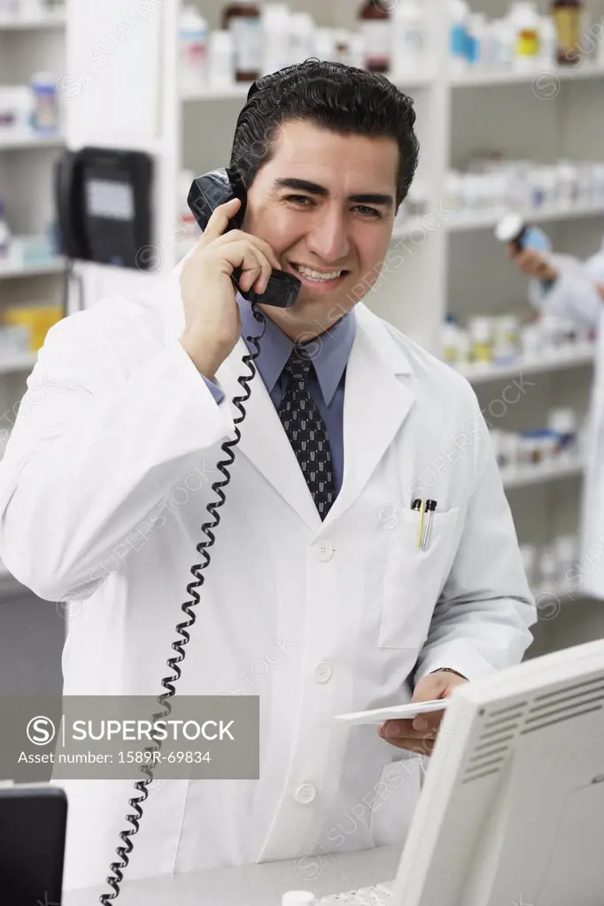Portrait of Hispanic male pharmacist talking on telephone