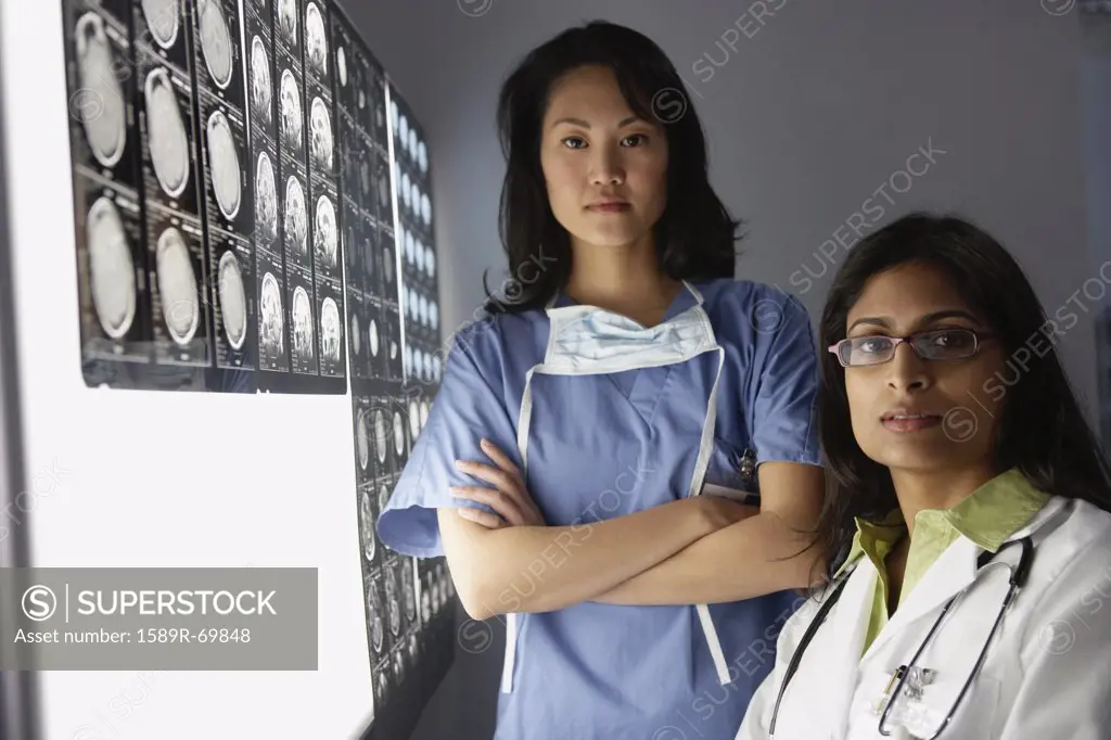 Female doctors next to x-rays