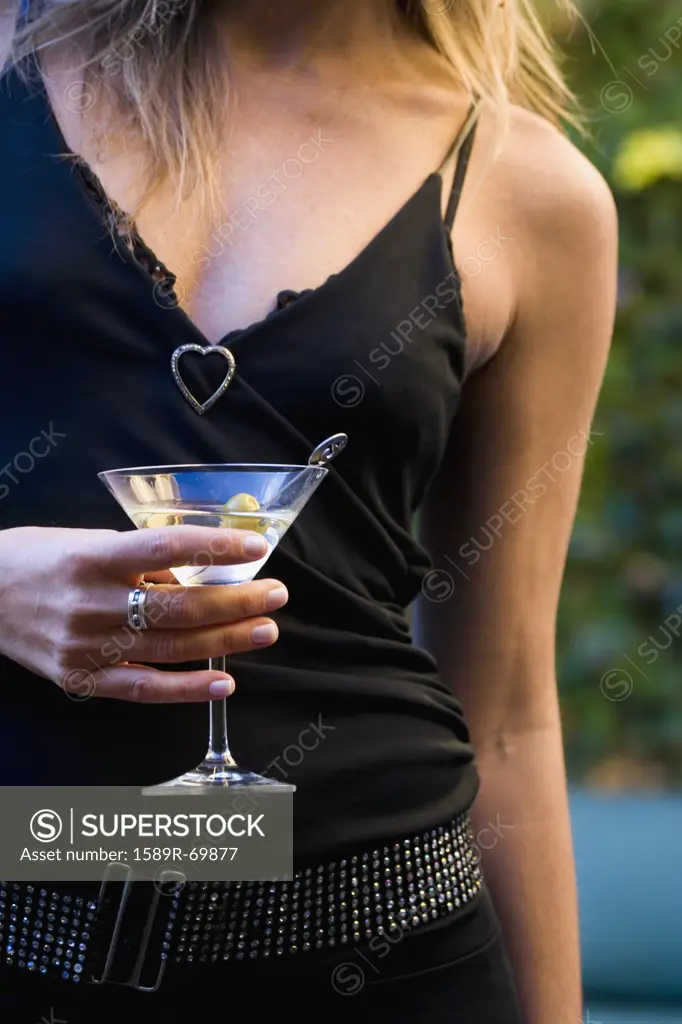 Close up of woman in fancy clothing holding martini
