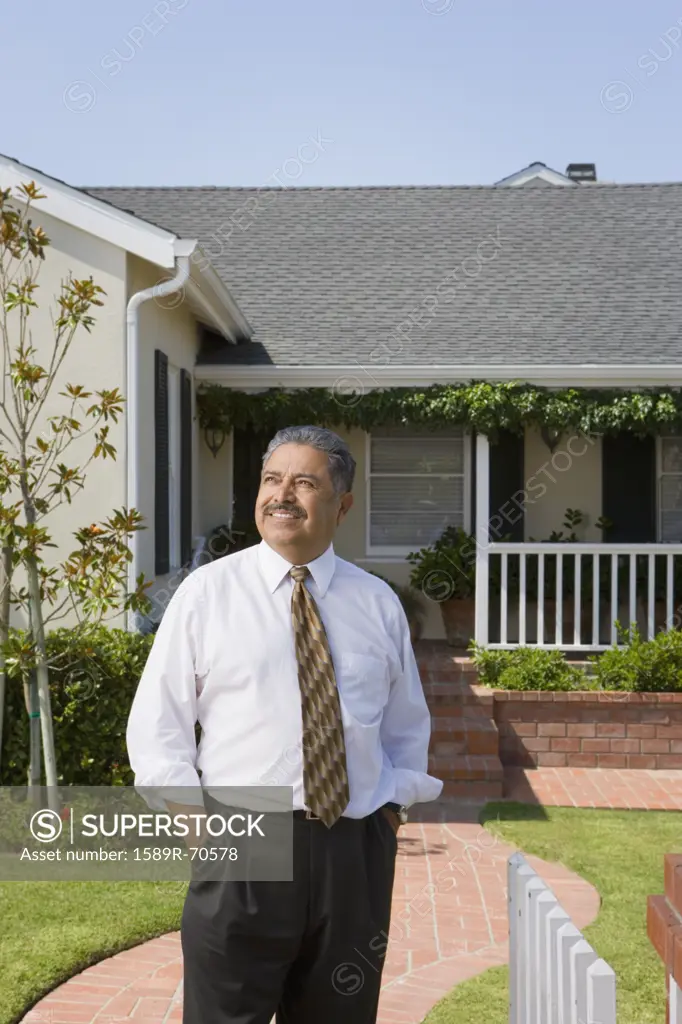 Portrait of middle-aged Hispanic man in front of house
