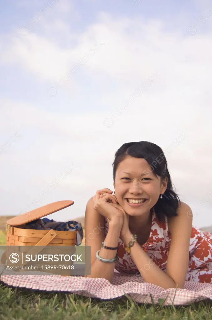 Portrait of Asian woman next to picnic basket