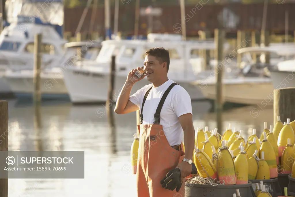 Hispanic fisherman talking on cell phone