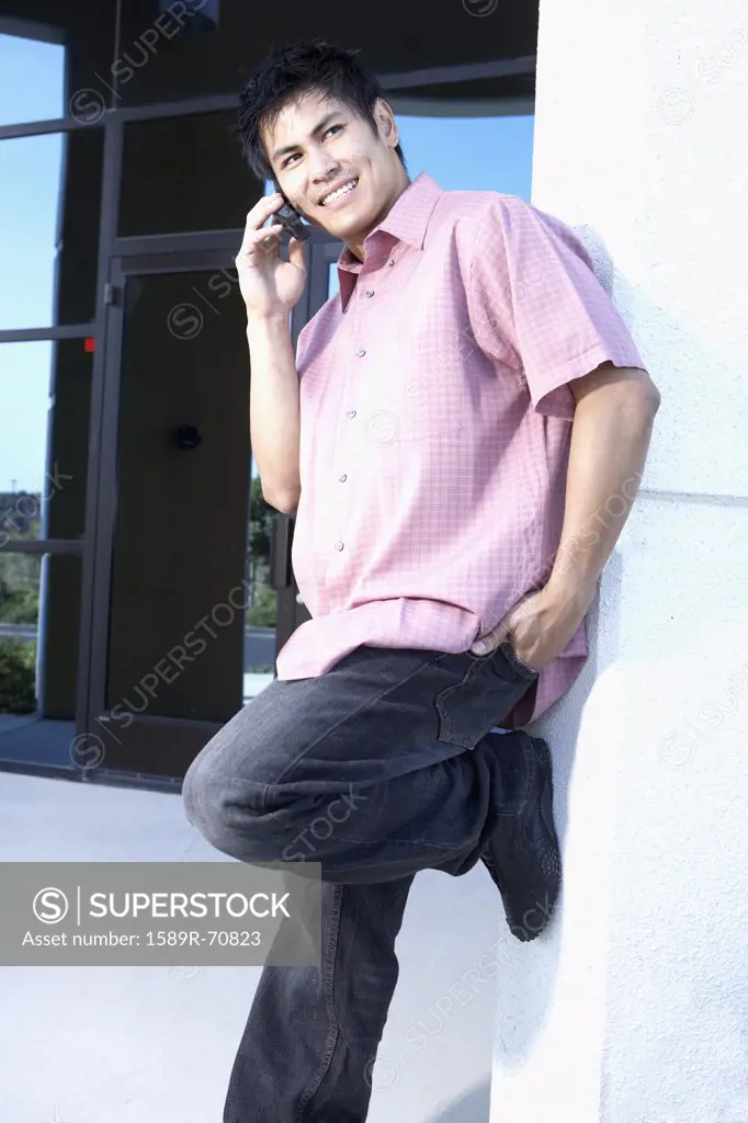 Young Asian man talking on cell phone