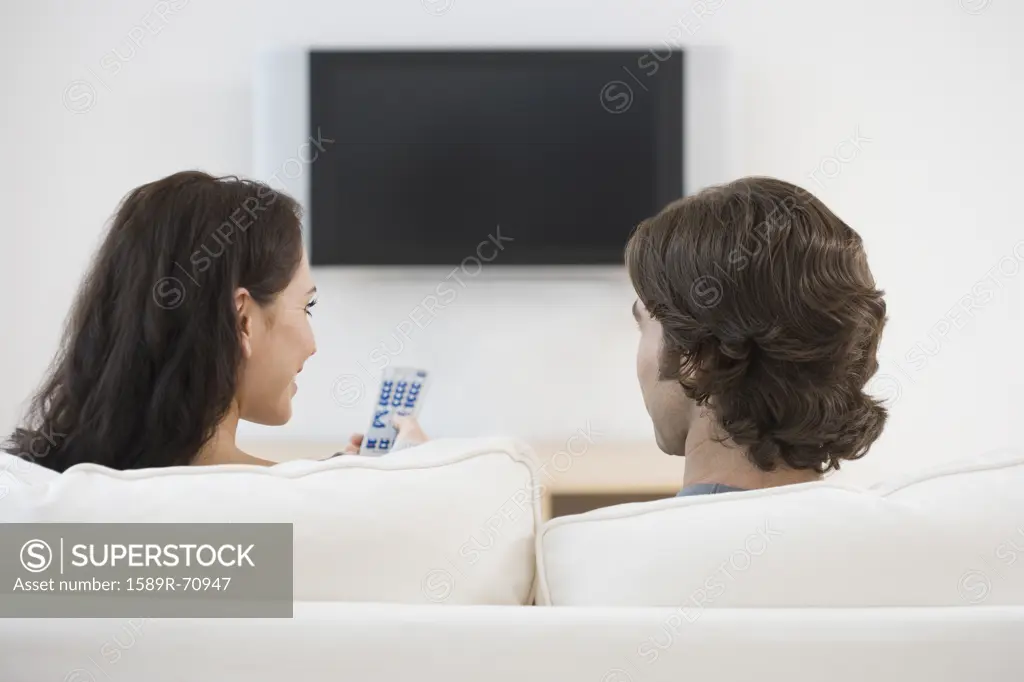 Rear view of couple watching television
