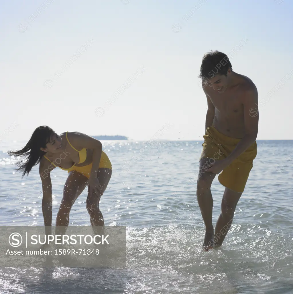 Couple playing in water at beach
